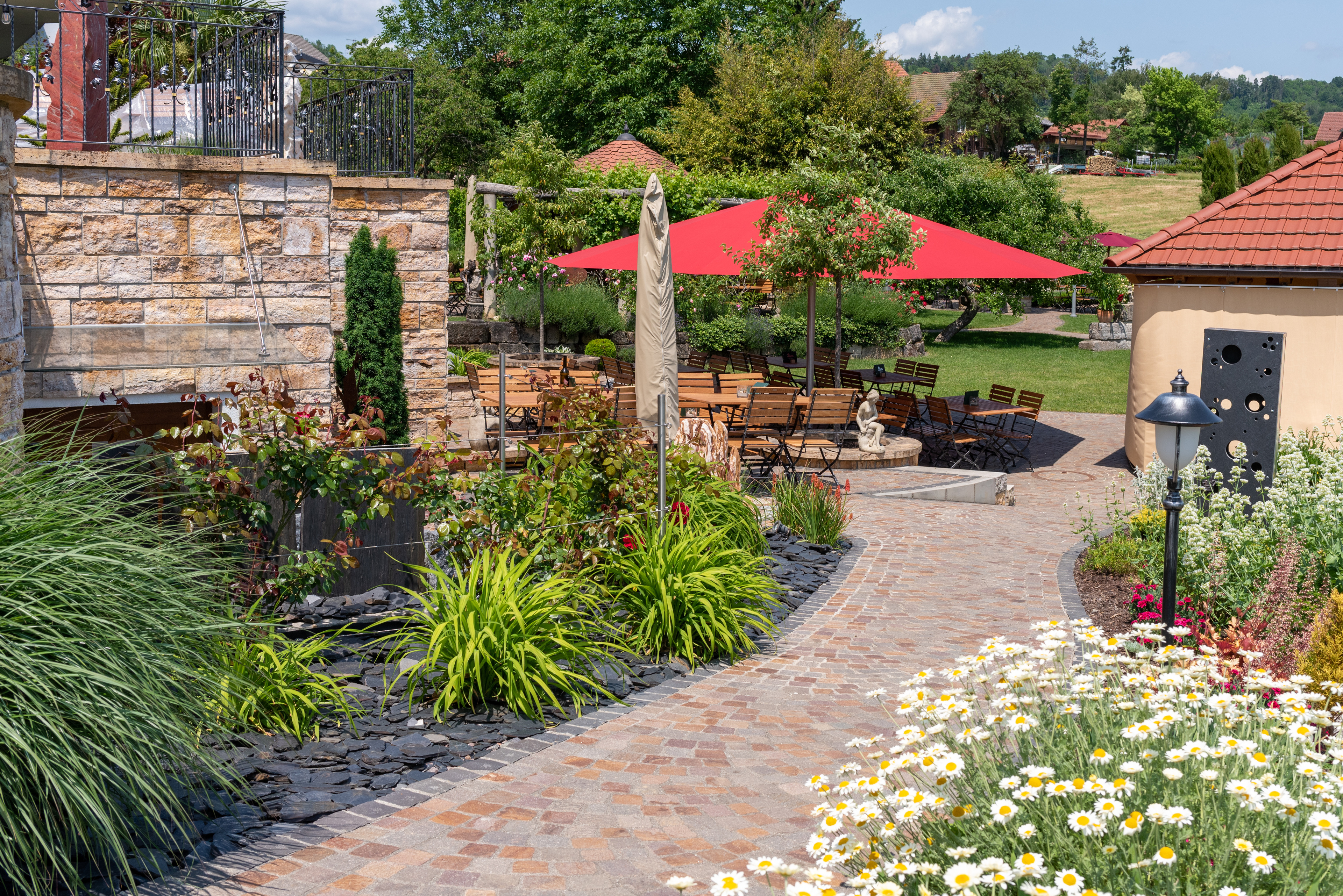 Terrasse mit Natursteinmauer und Sitzplätzen
