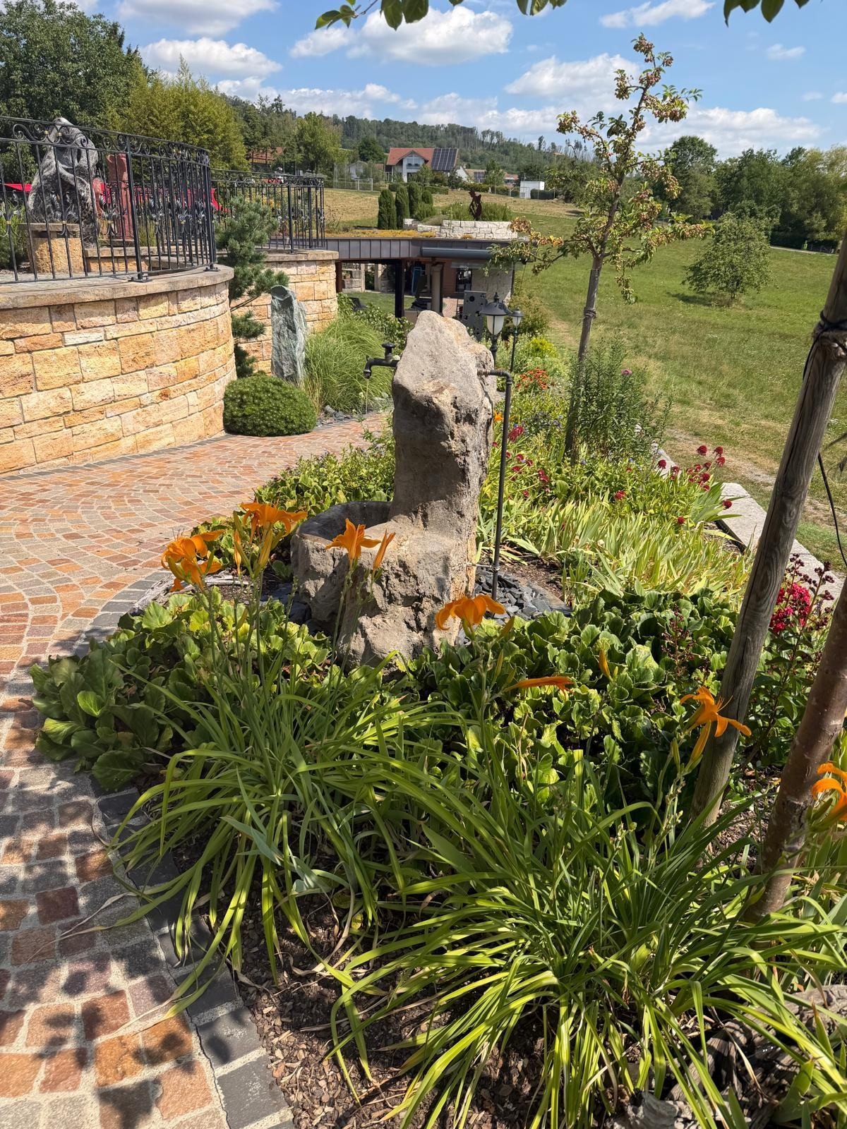 Nachher: Brunnen zwischen Taglilien