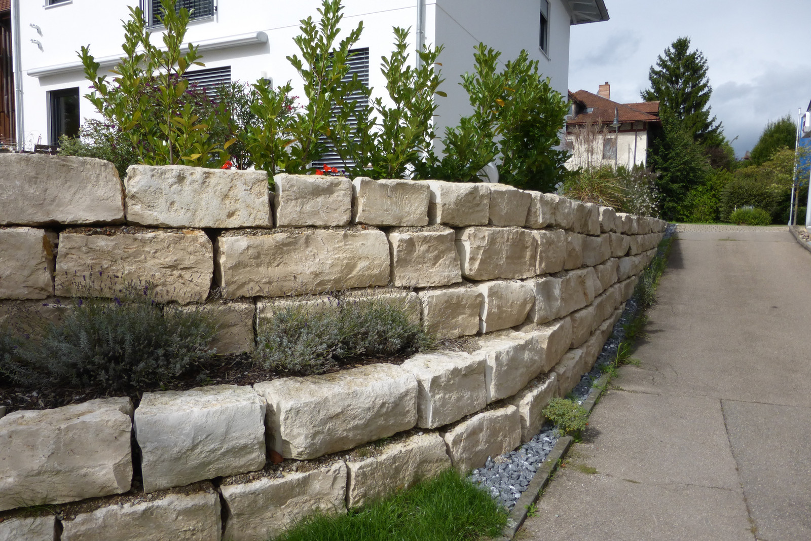 Mauer aus Kalksteinblöcken am Hang