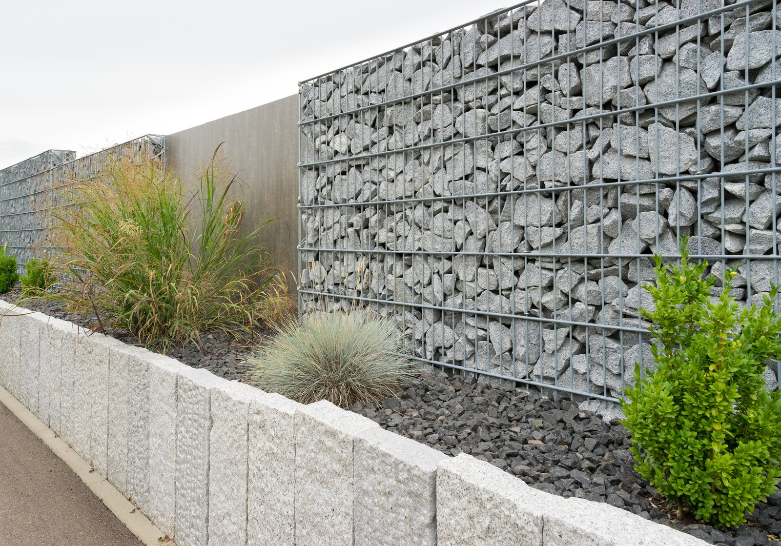 Gabionenwand mit Granit-Palisaden und Bepflanzung