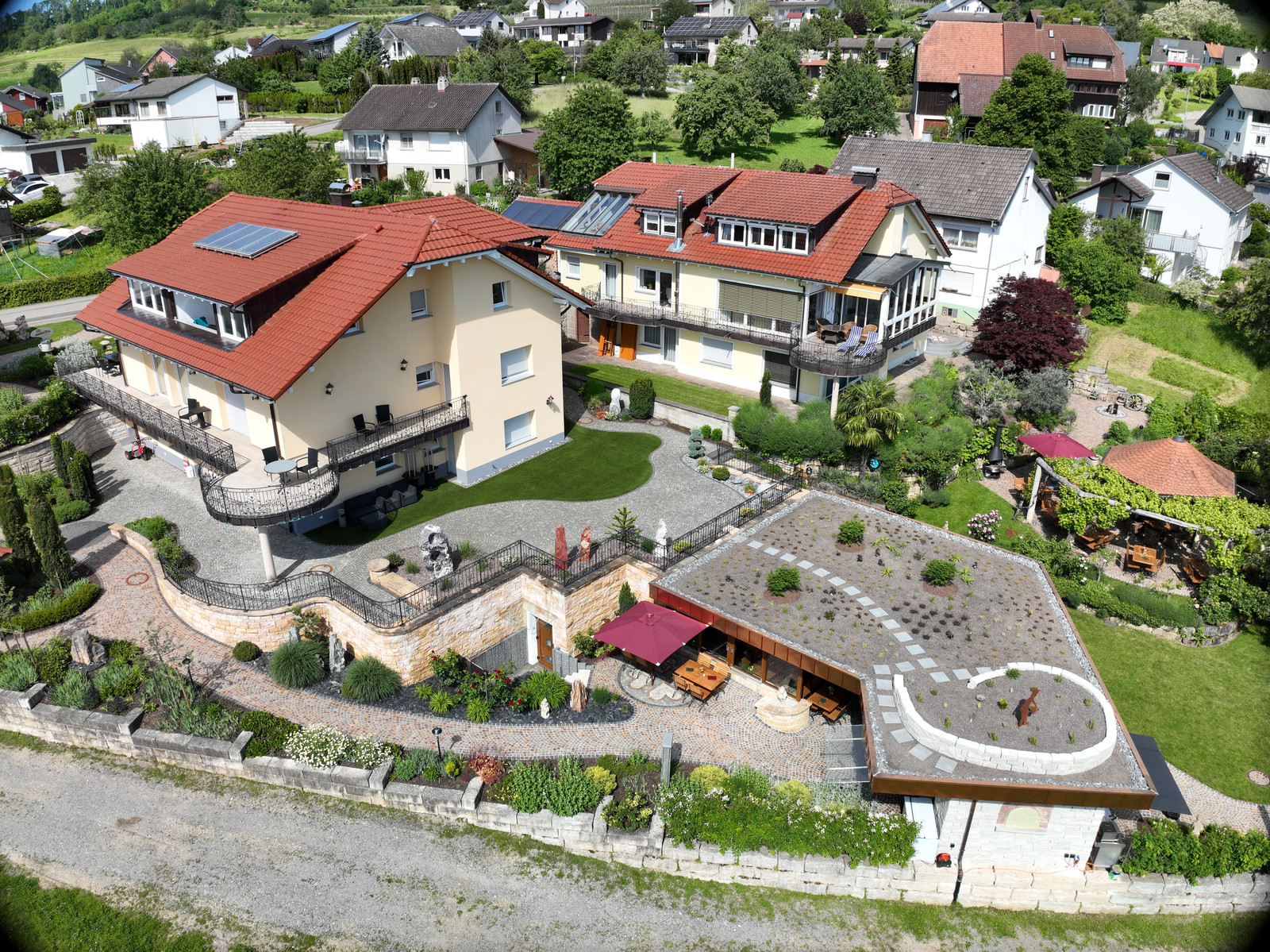 Luftaufnahme einer terrassierten Gartenanlage am Hang