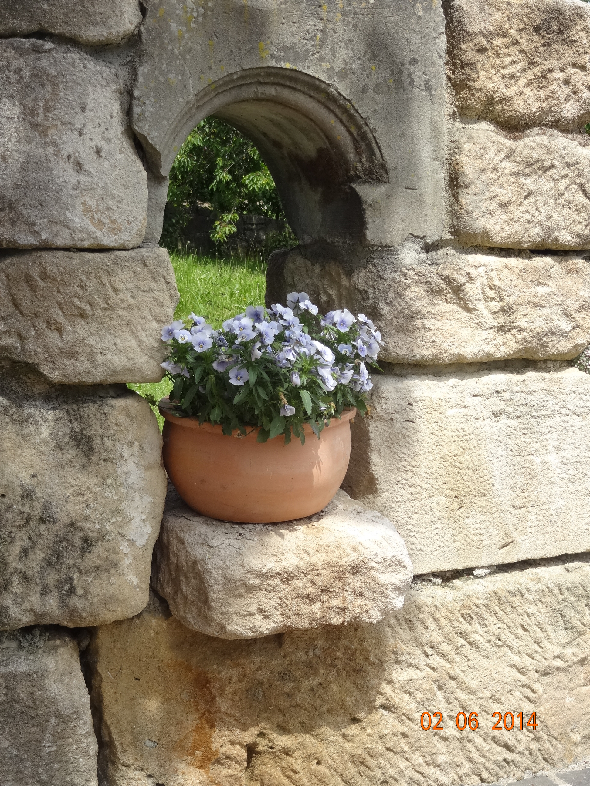 Nische mit Blumen in einer Natursteinmauer