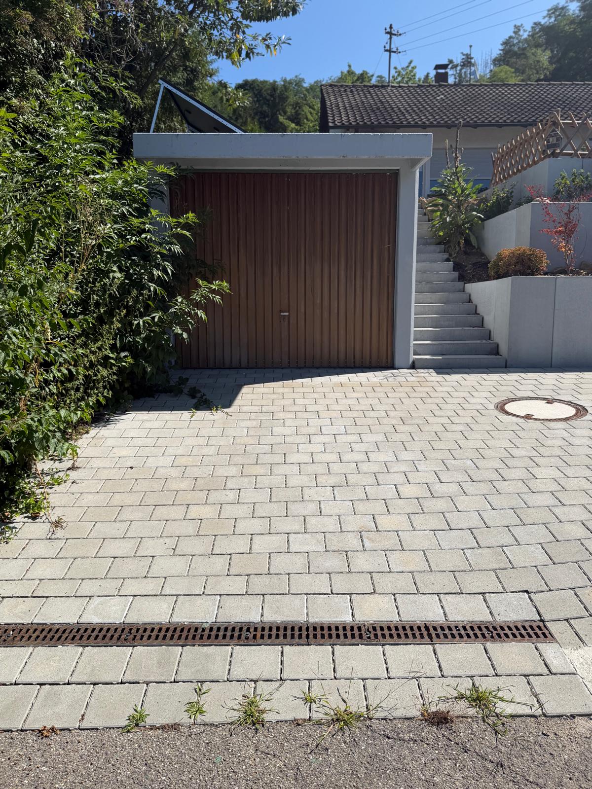 Plattenbelag vor der Garage mit Treppenaufgang