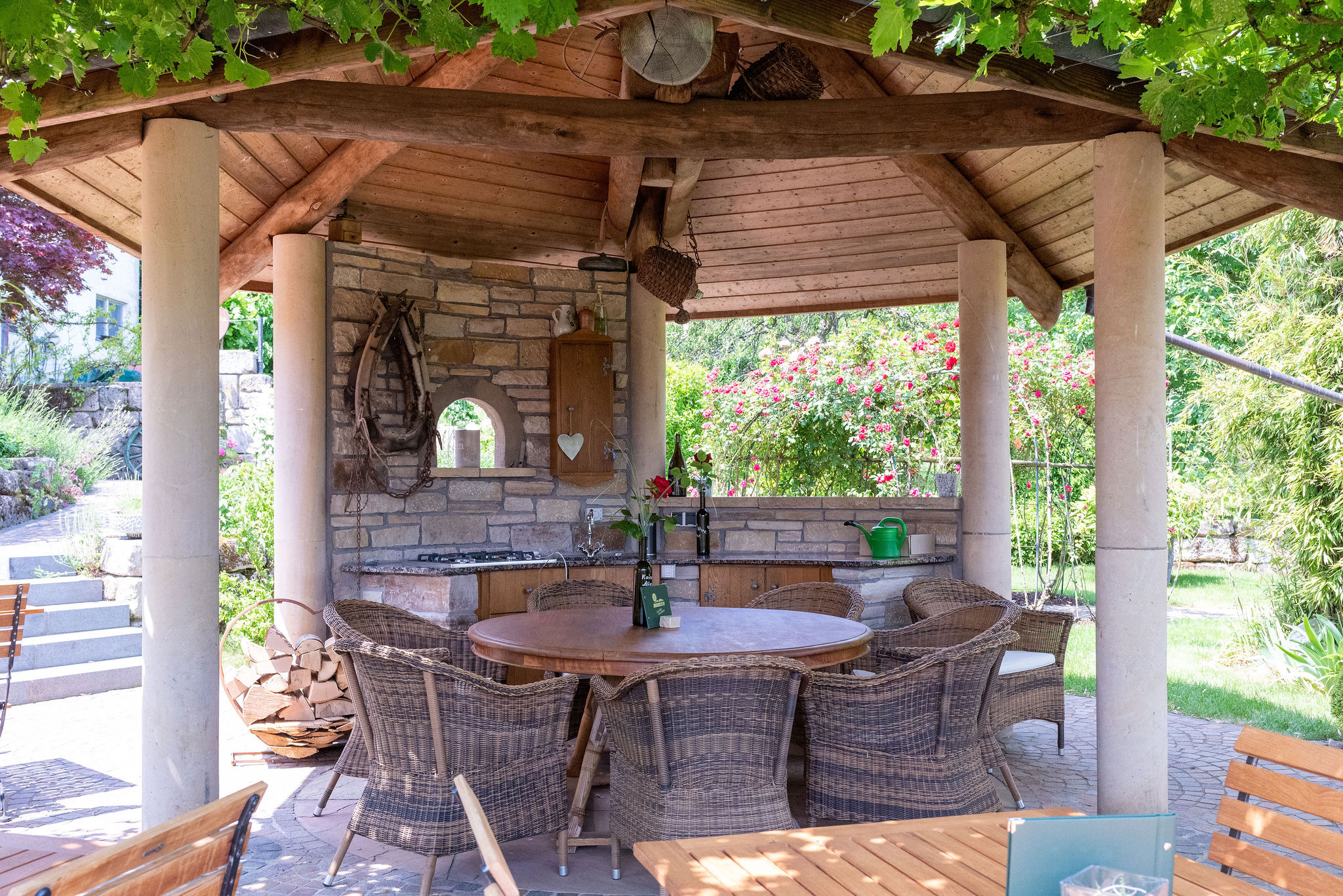 Pavillon im Sommergarten – gedeckter Tisch unter Rosen