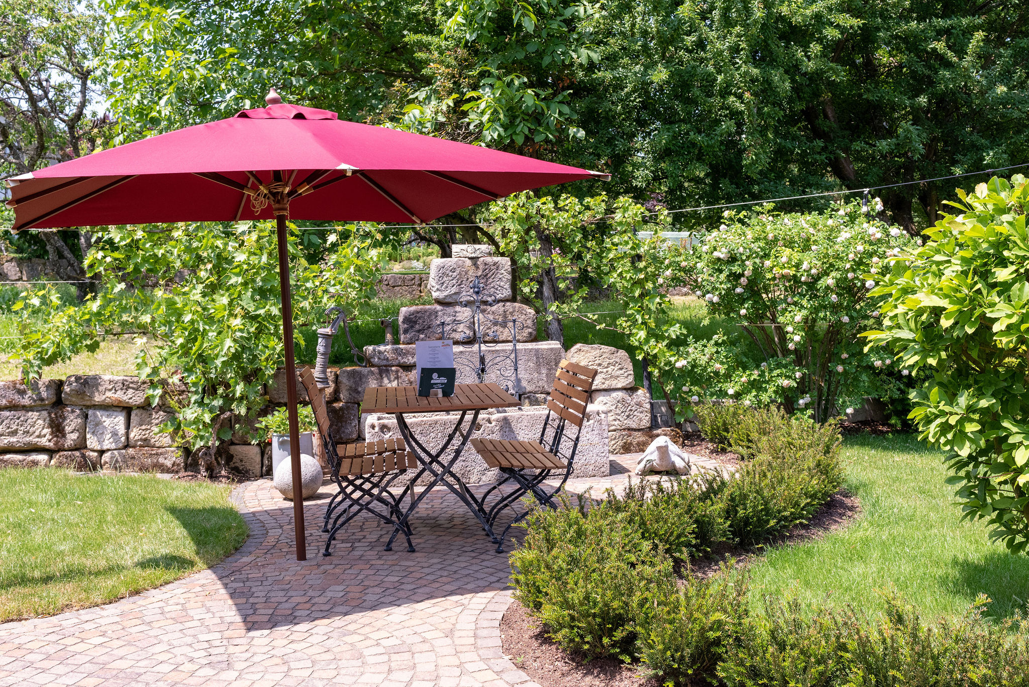 Café-Garten mit rotem Sonnenschirm